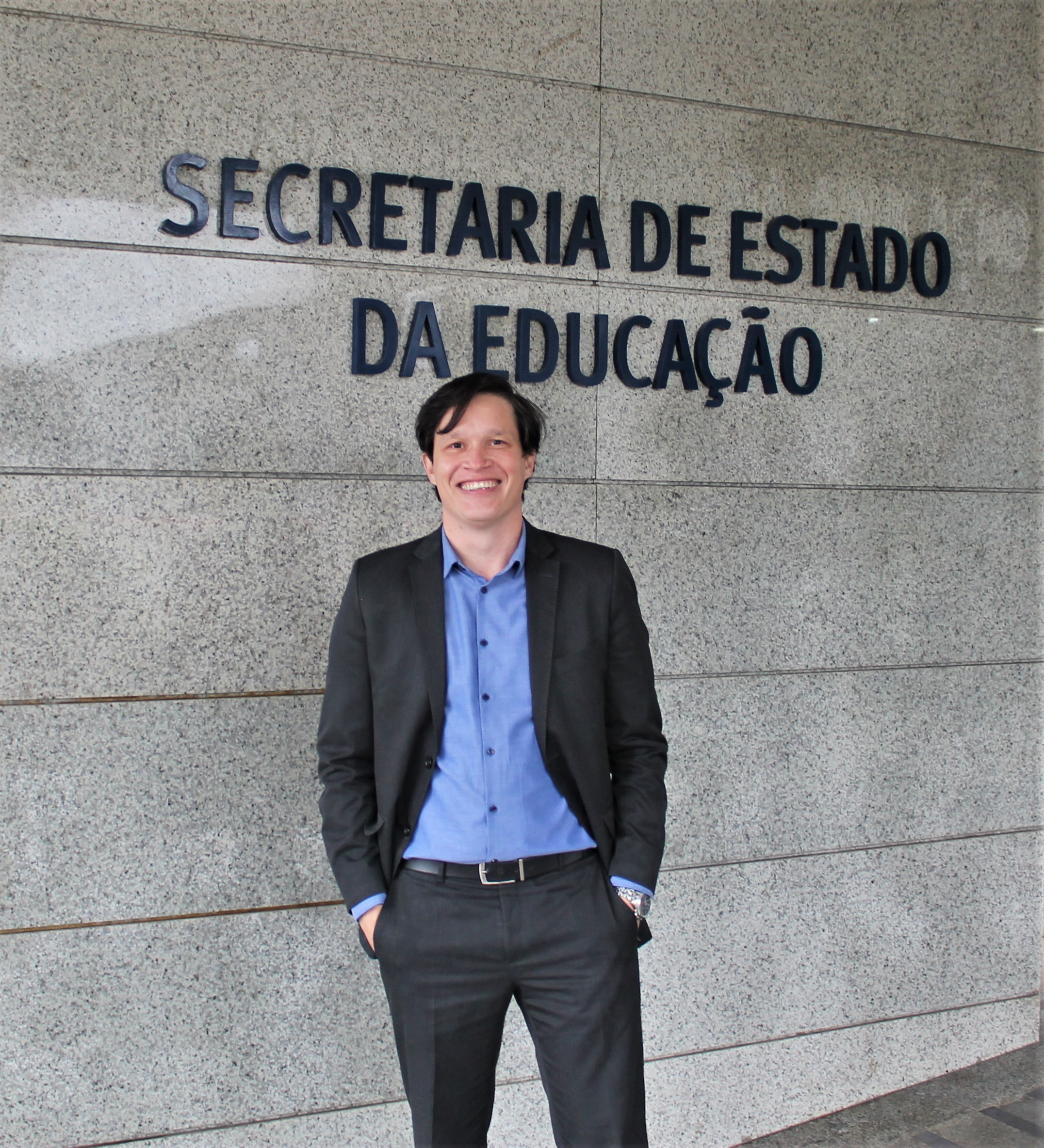 Foto do Diretor-Geral Vinicius Neiva em frente à entrada da Seed em Curitiba