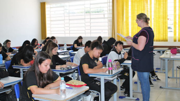 Foto de uma sala de aula com alunos e professora