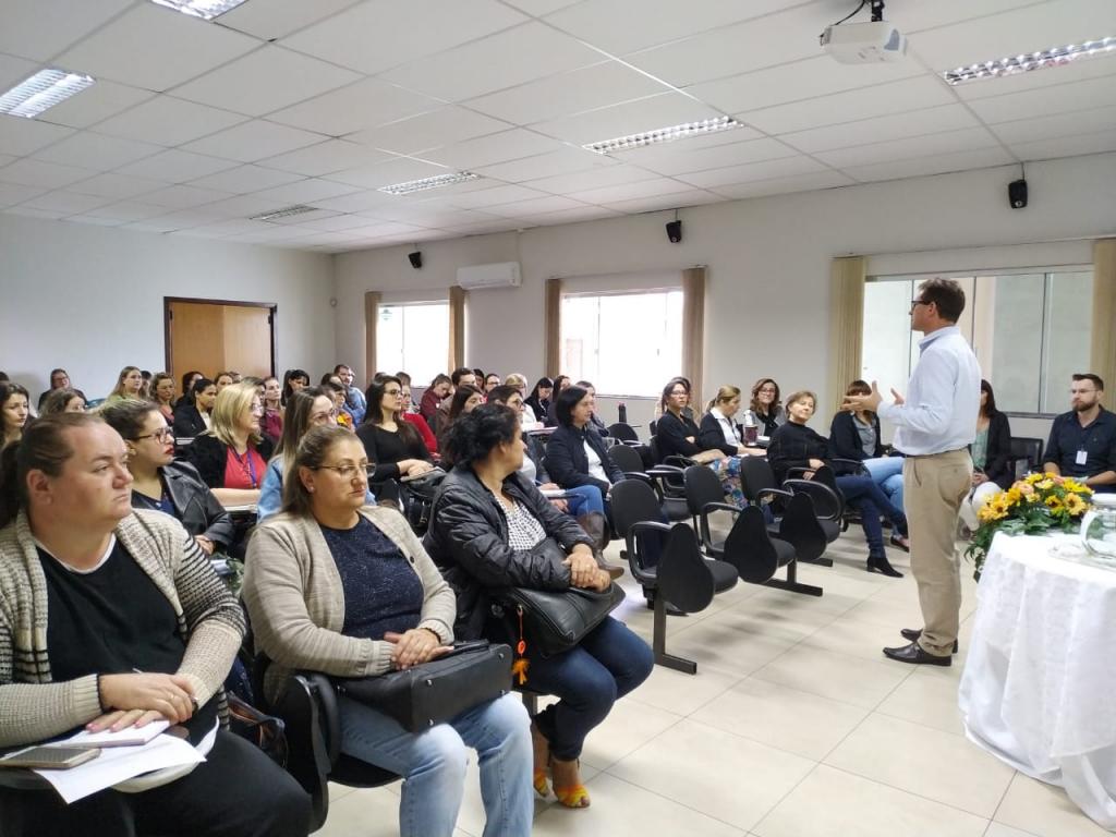 Professores em uma sala, escutando uma palestra