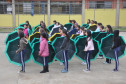 Alunos do Colégio Estadual Aníbal Khury Neto durante ensairo do mosaico da bandeira nacional feito com guarda-chuvas coloridos.