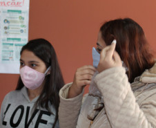 Famílias que foram buscar o kit merenda na Escola Professora Marli Queiroz também ganharam máscaras produzidas pela diretora e sua equipe