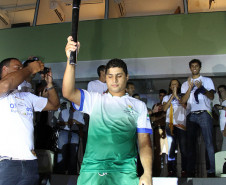 Para-atleta paranaense carregando a tocha olímpica.