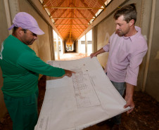 Leonir Noronha, encarregado das obras da nova sede do Colégio Estadual José Orestes Preima, mostra a planta da obra para o diretor do colégio, José Adriano Iulek. Prudentópolis, 14/05/2013.  