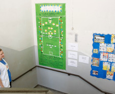 No Colégio de Educação Especial Mercedes Stresser, em Curitiba, as atividades estão acontecendo nas disciplinas de Educação Física e de Arte. Cerca de 40 alunos trazem materiais relacionados ao futebol e estão montando painéis que são distribuídos por toda a escola.