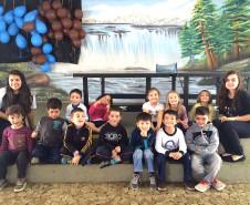 Ana Laura, do 2° ano do ensino, dá aulas de inglês para alunos das séries iniciais do ensino fundamental nas escolas municipais da sua cidade uma vez por semana há dois anos e meio