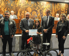 Durante a posse dos conselheiros, a aluna Eduarda Kotoski de Lima, do Colégio Estadual Dona Carola, de Curitiba, recebeu uma das dez bicicletas sorteadas num evento sobre educação no trânsito, realizado no Museu Oscar Niemeyer. As bicicletas foram oferecidas pelo “Instituto Sou Cidadão”.