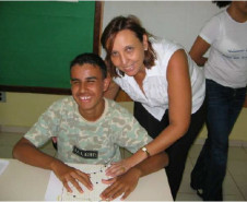 Deficiente visual utilizando o livro em braille produzido pelos internos