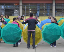 Alunos do Colégio Estadual Aníbal Khury Neto durante ensairo do mosaico da bandeira nacional feito com guarda-chuvas coloridos.
