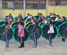 Alunos do Colégio Estadual Aníbal Khury Neto durante ensairo do mosaico da bandeira nacional feito com guarda-chuvas coloridos.