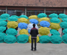 Alunos do Colégio Estadual Aníbal Khury Neto durante ensairo do mosaico da bandeira nacional feito com guarda-chuvas coloridos.