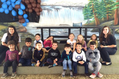 Ana Laura, do 2° ano do ensino, dá aulas de inglês para alunos das séries iniciais do ensino fundamental nas escolas municipais da sua cidade uma vez por semana há dois anos e meio