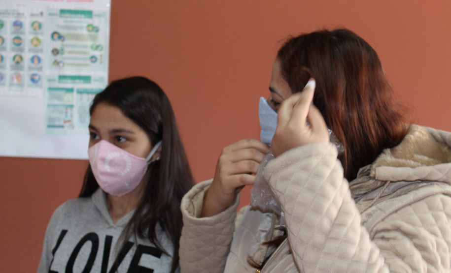 Famílias que foram buscar o kit merenda na Escola Professora Marli Queiroz também ganharam máscaras produzidas pela diretora e sua equipe