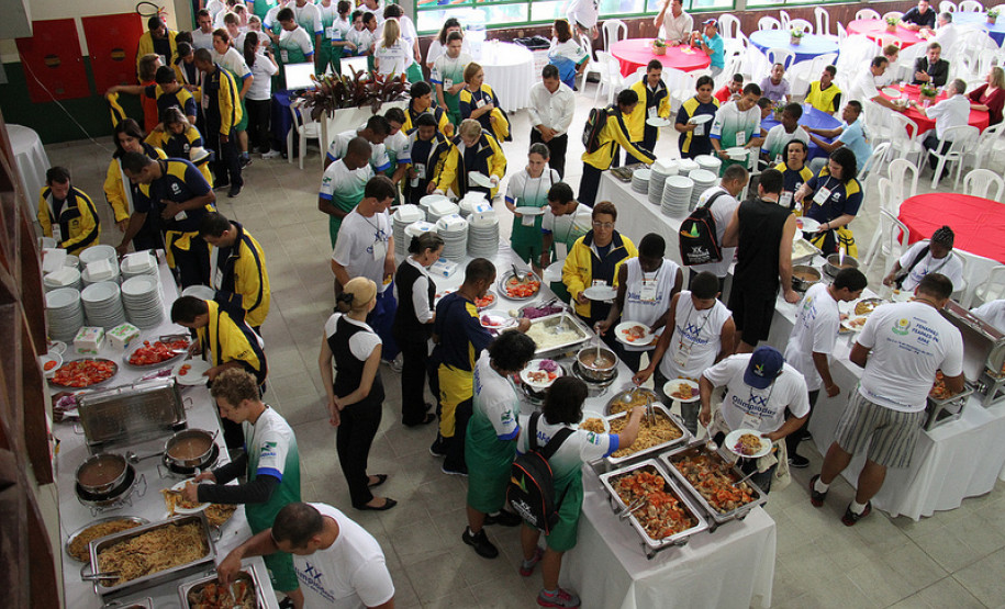 Para-atletas e participantes se alimentam antes da cerimônia de abertura.