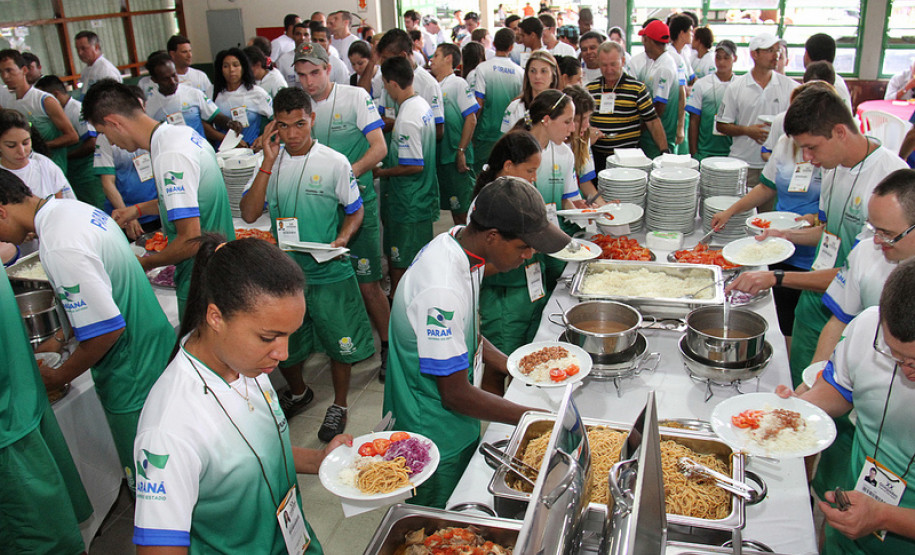 Para-atletas e participantes se alimentam antes da cerimônia de abertura.