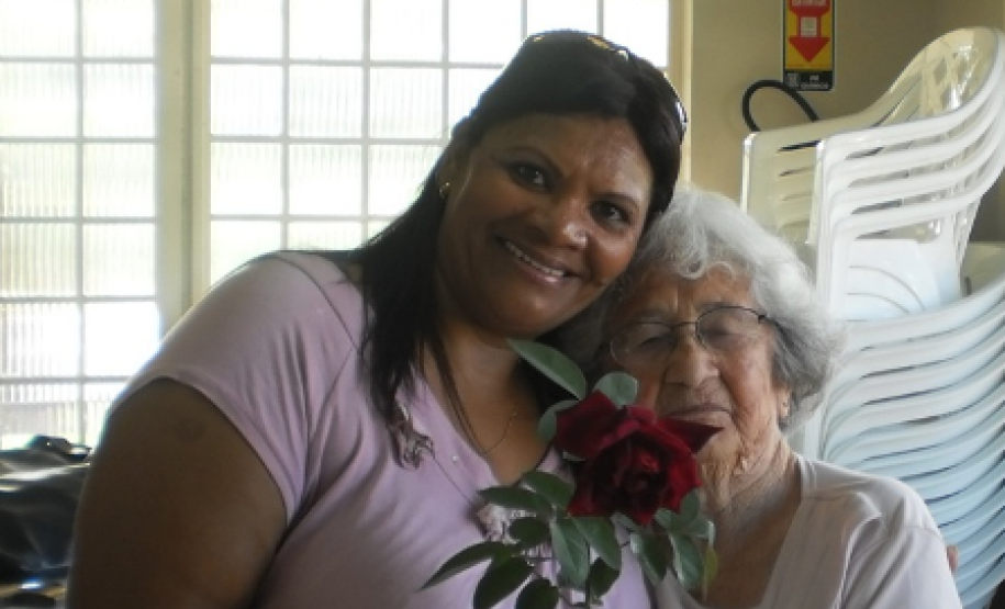 Aos 85 anos de vida Dona Euzébia recebe homenagem prestada por Jandira, aluna mais jovem da turma de alfabetização que se reúne na Associação de Moradores do bairro Tancredo Neves, em Toledo.