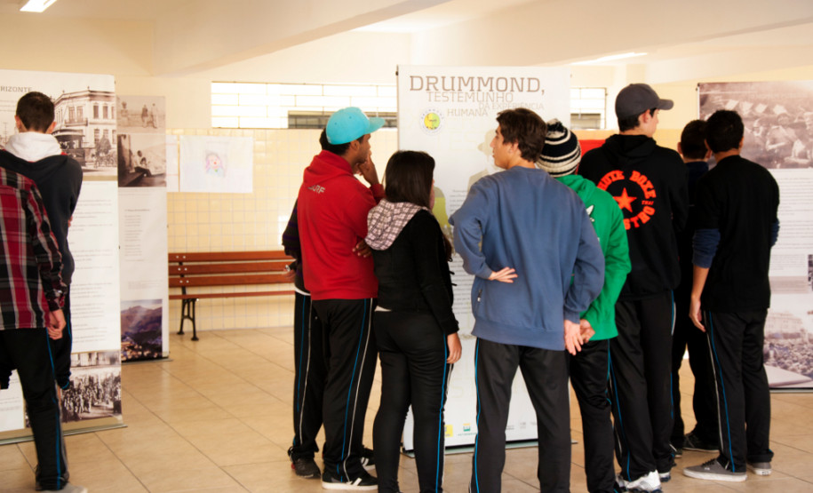 Poesia de Carlos Drumonnd percorre escolas estaduais Exposição itinerante leva 15 banners de dupla face com biografia e principais textos do poeta para escolas que trabalham a obra de Drummond.