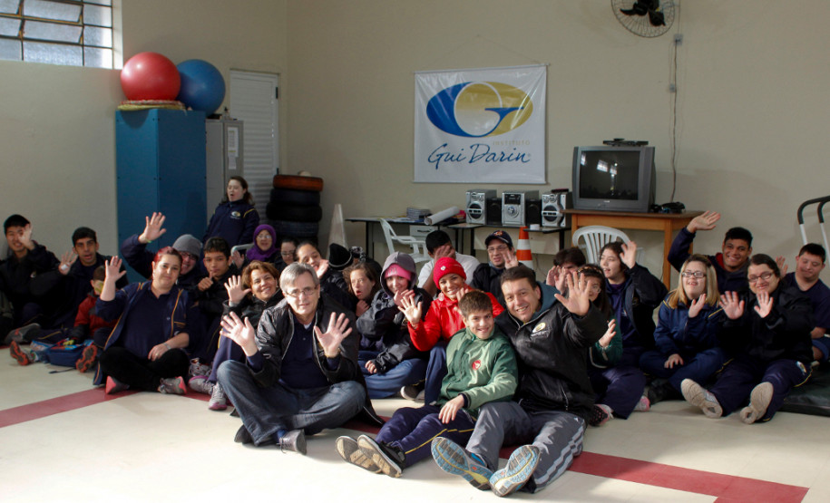 Marcio Darin (ao centro), diretor da Escola de Educação Especial Guilherme Canto Darin, com alunos e professores da escola. Curitiba, 21/08/2013.
