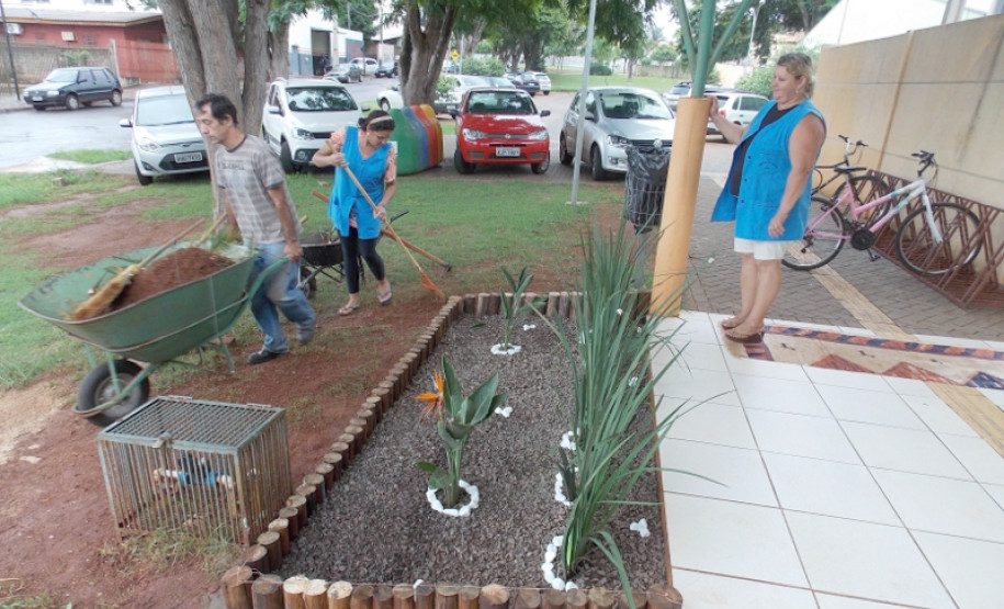 Funcionárias Agente I, por iniciativa própria, fazendo o jardim na frente da escola.