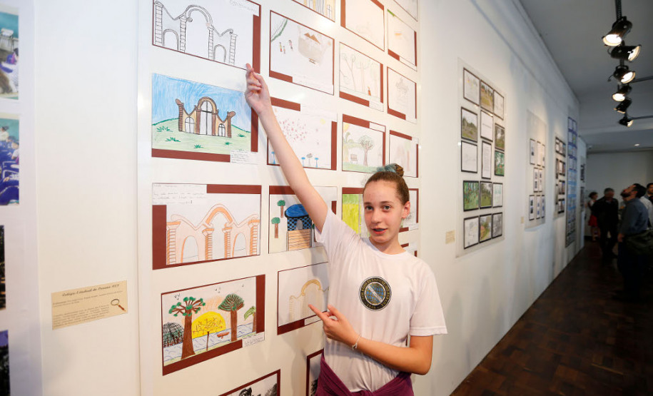 Quem for até o Museu Paranaense, no bairro Alto São Francisco, terá a oportunidade de conhecer um pouco mais sobre a história de prédios, avenidas, pontos turísticos e personagens que marcaram a história da capital paranaense sob ponto de vista de alunos do ensino fundamental, como a pesquisa feita pela aluna Júlia Ramalho Piontkicvicz, 11 anos, do 6° ano, que retrata a história do portal do Passeio Público.