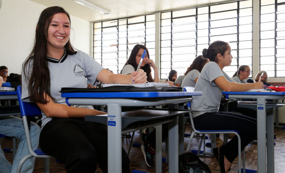 290 mil novos conjuntos de carteiras e cadeiras No Colégio Estadual Tiradentes, em São José dos Pinhais, na Região Metropolitana de Curitiba, os 1,4 mil estudantes do ensino fundamental e médio já estão usando os novos mobiliários desde dezembro do ano passado. A escola recebeu 420 carteiras e cadeiras.<br / >
<br />
Sua colega, Janaína Cavaleiro Rosa, 17 anos, 3°, também aprovou os novos conjuntos. “São mais confortáveis e isso contribui para prestarmos mais atenção nas aulas”.