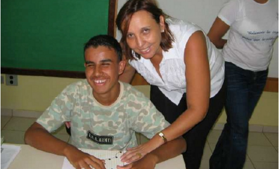 Deficiente visual utilizando o livro em braille produzido pelos internos