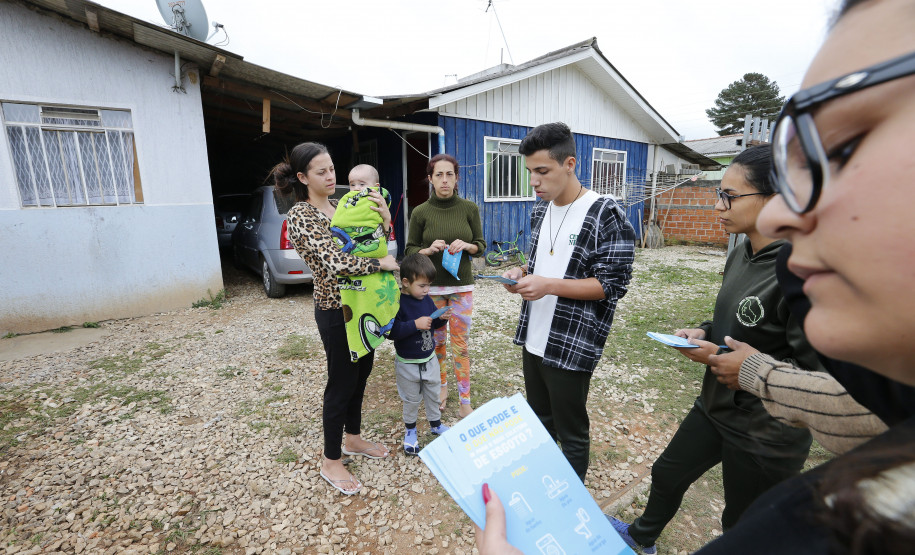 Secretaria Estadual de Educação do Paraná; Alunos do CEEP Newton Freire participão junto com a Sanepar de ação no Rio Timbu, no bairro Jardim Paulista, destribuindo panfletos para os moradores, plantando árvores e coletando água do rio para análise, na foto alunos entregam panfletos para a moradora Silvana da Rosa de Oliveira. 25-05-18. Foto: Hedeson Alves