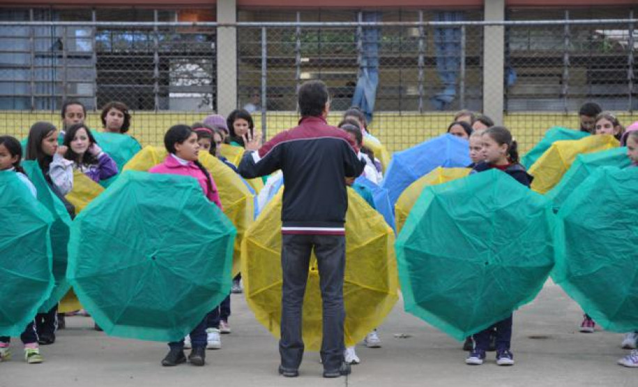 Alunos do Colégio Estadual Aníbal Khury Neto durante ensairo do mosaico da bandeira nacional feito com guarda-chuvas coloridos.