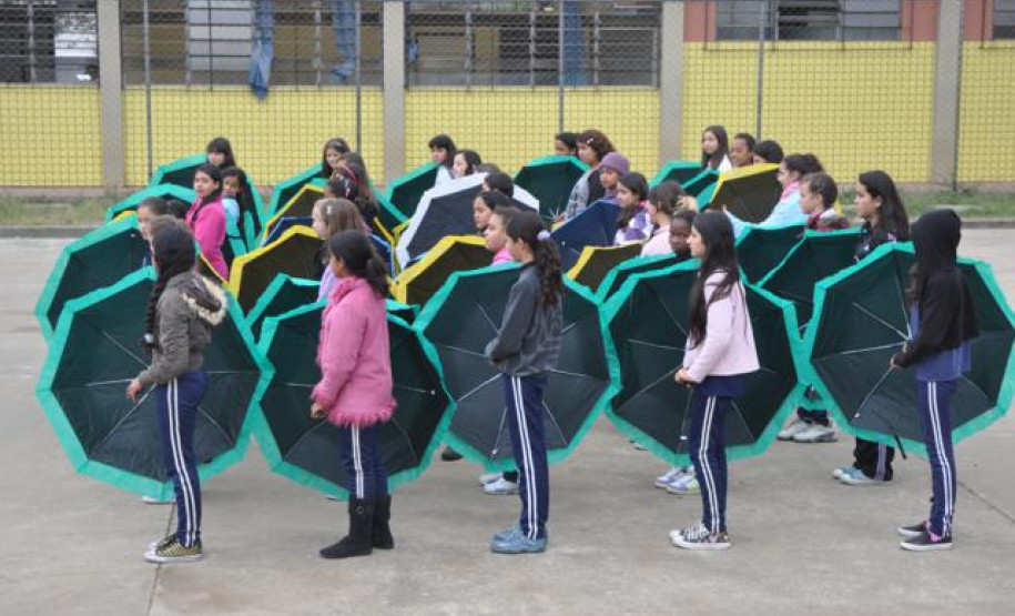 Alunos do Colégio Estadual Aníbal Khury Neto durante ensairo do mosaico da bandeira nacional feito com guarda-chuvas coloridos.