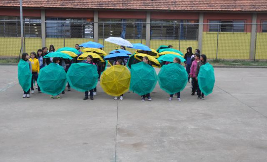 Alunos do Colégio Estadual Aníbal Khury Neto durante ensairo do mosaico da bandeira nacional feito com guarda-chuvas coloridos.